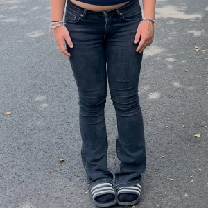 Svarta bootcut jeans från Gina Tricot - Säljer ett par svarta bootcut jeans från gina tricot i storlek 36. Jeansen har klassisk femficksdesign, dragkedja och knapp framtill samt snygga kopparfärgade nitar. Modellen är midwaist och har en lätt utsvängd passform nertill.