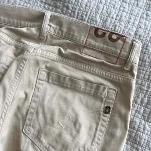 Beige Dondup chinos (George) - Snygga beige chinos från Dondup med raka ben och klassiska bakfickor. Perfekta för en clean och stilren look. Tillverkade i mjuk bomull för skön känsla hela dagen. 