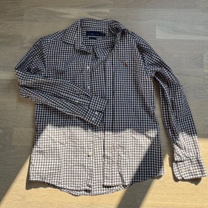  Ralph Lauren skjorta🌟 - Snygg brun och vit rutig skjorta från Polo Ralph Lauren med klassisk krage och broderad logga på bröstet. Skjortan har långa ärmar och knäppning framtill. Perfekt för en stilren och avslappnad look. Skjortan är i storlek S och är sprillans ny! Inga defekter osv!