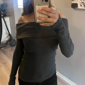 Mörkgrå offshoulder stickad tröja - Säljer en mörkgrå stickad tröja med offshoulder-design och långa ärmar. Den är storlek S🩶
