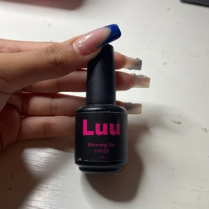 Luu Blooming Gel UV/LED 15ml - Luu Blooming Gel är en transparent gel för naglar som används med UV/LED-lampa. Perfekt för att skapa coola effekter och nail art. Kommer i en svart flaska med rosa text och har en smidig penselapplikator. innehåller 15 ml.