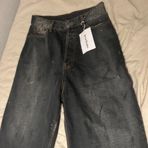 Svarta wide jeans från Acne Studios - Säljer ett par svarta jeans från Acne Studios med bred passform och klassiska fem fickor. Jeansen har kontrastsömmar och en snygg tvättad look. Perfekta för dig som gillar en avslappnad och trendig stil. Jag använde ai för texten… Dessa jeans är majestic! waist: 40 cm rise: 38 cm inseam: 65 cm leg opening: 27 cm