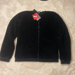 Svart ulltröja från Puma  - Säljer en snygg och bekväm från Puma i klassisk svart färg. Perfekt för kyliga dagar eller som ett stilrent lager under jackan. Passar S/XS