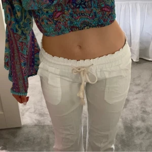 Roxy liknande linnebyxor  - Säljer ett par vita linnebyxor med raka ben och snörning i midjan. De är väldigt korta och små och med en lågmidja som jag har sytt om noggrannt själv 