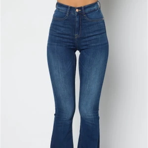 Blå bootcut jeans från Bubbleroom - Snygga blå jeans från Bubbleroom i bootcut-modell med hög midja. Jeansen har klassisk femficksdesign, dragkedja och knapp framtill samt lätt utsvängda ben. Materialet är mjukt denim som sitter skönt och ger en stilren look och formar en jätte snygg. Jätte stretchig dock!! Använd ett par gånger så det har blivit mjuk mellan låren men går fortfarande att använda. KOSTAR  499kr men jag säljer för 250 bara. Pris kan diskuteras 💕💕