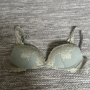 Intimissimi bh - Grön bh med spetsdetalj över hela framsidan och axelbanden. Justerbara axelband och klassisk hysk- och hakknäppning bak. Har nån svart färg på insidan som man kan se på bilden men ingenting man tänker på. nypris 520