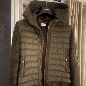 Olivgrön Moncler Cardigan - Moncler cardigan olivgrön, gott skick, finns en mindre skada på luvan, storlek S
