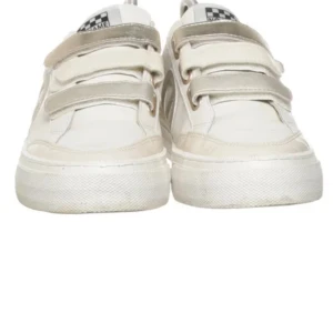 No Name Strike Straps sneakers guld/vit - Snygga sneakers från No Name i vitt skinn med detaljer i ljusguld. Skorna har breda kardborreband, rund tå och platt sula. Ikonisk No Name-logga på sidan och metallic-detaljer på häl och remmar. Perfekta för dig som gillar en clean men ändå trendig look.