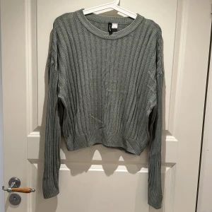 Grön ribbad stickad tröja - Grön stickad tröja från H&M med ribbat mönster. 