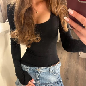 Svart långärmad topp Gina Tricot XS - Svart långärmad topp från Gina  tricot i storlek xs. Soft touch material och sitter väldigt smickrande på kroppen :) även små slits i ärmarna. Använd men i mycket bra skick! 