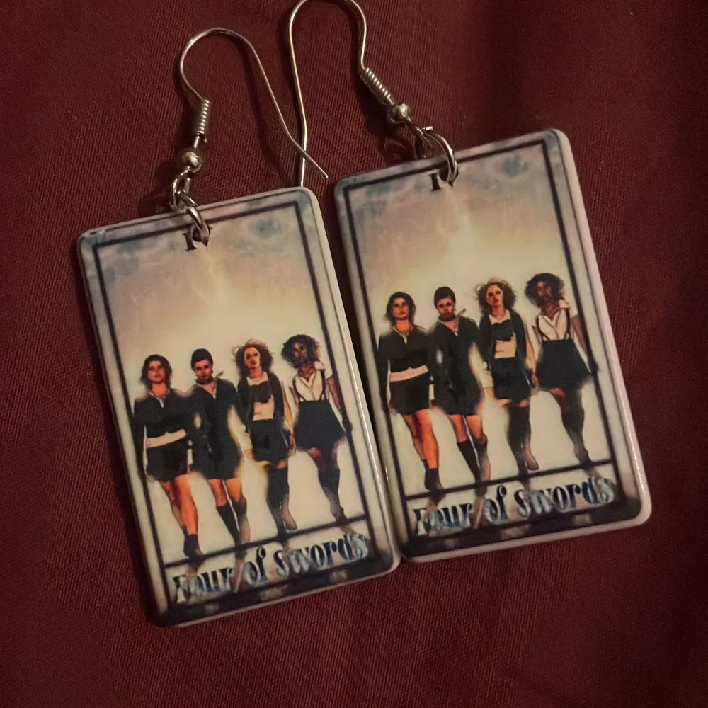Unika örhängen med rektangulära plattor som har ett tryck av The Craft. Texten 'Four of Swords' syns längst ner. Perfekt för den som vill ha något annorlunda och iögonfallande.. Asusteet.