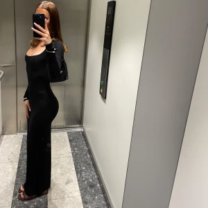 Skims klänning - Elegant svart långklänning från Skims med långärmad design och en tight passform. Köpt förra sommaren, använd fåtal gånger. 