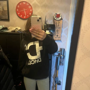 Svart hoodie dirtcult  - Säljer en svart hoodie med stor vit text på framsidan. Den har en klassisk design med en bekväm passform och en stor huva. Perfekt för en avslappnad stil.