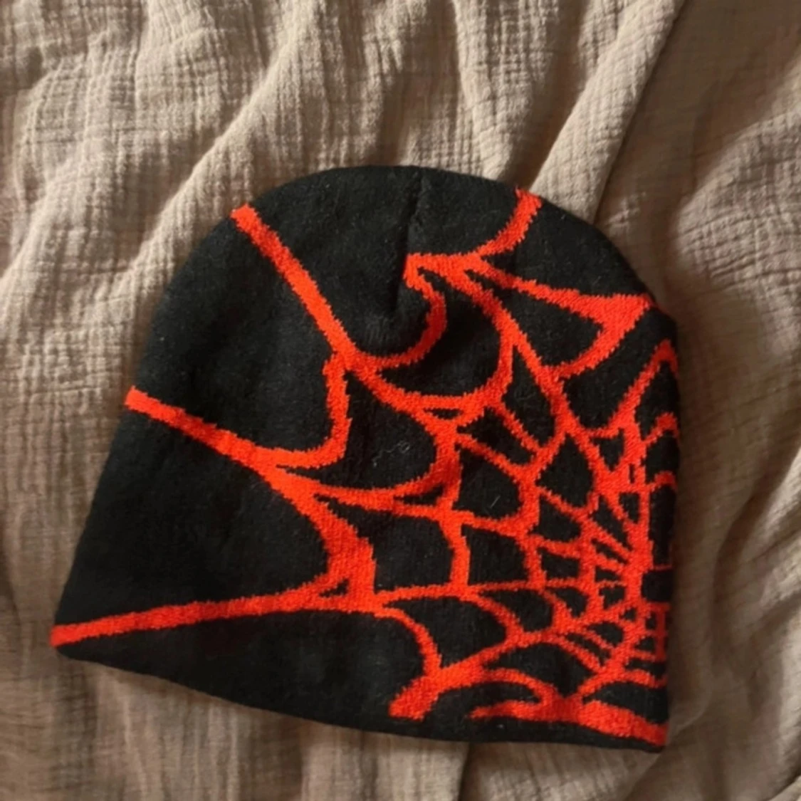 Svart mössa med spindelnätsmönster