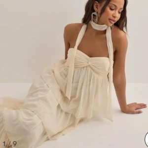 Balklänning Nelly  - Elegant axelbandslös långklänning med flera lager som ger en romantisk look. Perfekt för speciella tillfällen. Den är beige har lappen kvar. Nypris 699kr