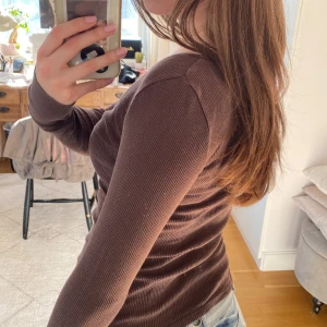 Brun ribbad topp med knappar - Säljer en brun ribbad topp med lång ärm och knappar framtill. Så skön och snygg🤩storlek xs men sitter mer som en S 🥰skriv vid frågor!!💕💕