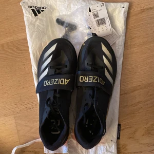 Adidas Adizero spikskor - Adizero TJ/PV. Godkända av WA. Använda nån enstaka tävling så de är i väldigt bra skick dock har de en liten skråma på kanten som ni ser på bild 4. Storlek UK 7