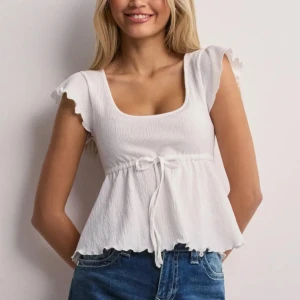 Vit ribbad topp med knyt - Söt vit ribbad topp med korta ärmar och knyt i midjan. Slutsåld på hemsidan! Knappt använd 🩷