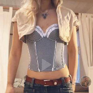 Svartvit rutig korsett - Säljer denna populära rutiga korsett topp med spetsfetaöjer. 