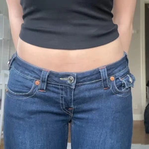 Mörkblåa jeans från True Religion - Mörkblåa jeans i modellen ”Joey Low Rise Flare”. Passar enligt mig både om man brukar ha s/xs/ 34/36 i byxor. 