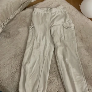 Vita cargopants från H&M - Säljer ett par vita cargopants från H&M. Byxorna har flera praktiska fickor och en bekväm passform. Perfekta för en avslappnad stil. 🕶️