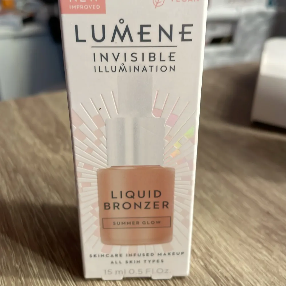 Säljer en Lumene Invisible Illumination Liquid Bronzer i nyansen Summer Glow. Denna lätta och byggbara bronzer ger en solkysst lyster och är idealisk för alla hudtyper. Förpackningen innehåller 15 ml och är vegansk. Den är endast swatchad på handen!. Beauty.
