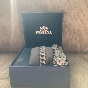 Glittrigt armband och halsband från Festina - Säljer ett elegant och glittrigt armband från Festina. Armbandet har en kedjedesign med gnistrande stenar som ger en lyxig känsla. Perfekt för att lägga till lite extra glamour till din stil. Levereras i en snygg presentask.