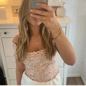 Blommig offshoulder topp - Säljer en söt blommig offshoulder topp med volangdetaljer. Den är tyvärr lite för liten för mig 🩷passar XS/S storleksmässigt. SÄLJER ÄVEN FLER JÄTTEFINA PLAGG I MIN PROFIL 