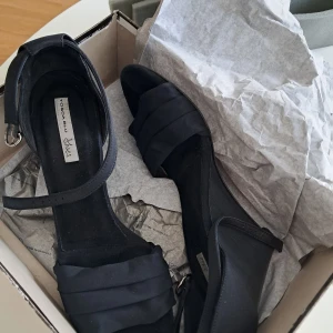 Svarta sandaler från Tosca Blu - Eleganta svarta sandaler från Tosca Blu med öppen tå och klack. De har en stilren design med remmar och en justerbar spänne runt ankeln. Perfekta för en stilfull look.