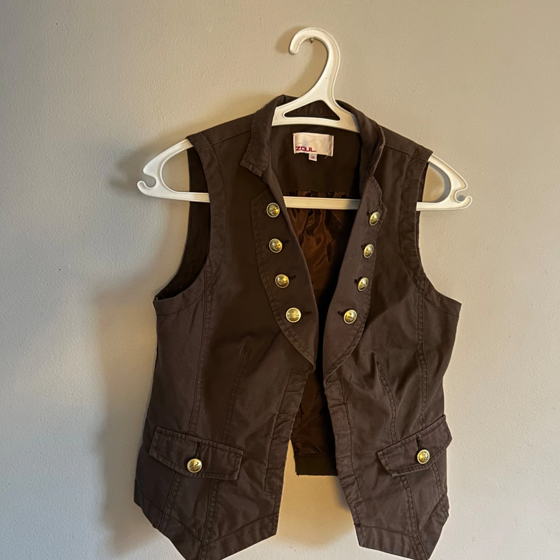 Brun väst med guldknappar