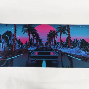 XXL Musmatta med retromotiv - Stor musmatta med ett retro futuristiskt motiv av en bil som kör mot en rosa solnedgång. Omgiven av palmer och berg i neonfärger, vilket ger en cool 80-talskänsla. Perfekt för gaming eller kontoret. 900mm x 400mm