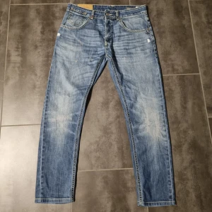 Blå jeans med knappgylf - Säljer ett par klassiska blå jeans med en snygg tvätt och knappgylf. De har en straight passform och normal midja. Perfekta för en avslappnad stil. Skick 9/10 riktigt bra inför vardagen om man vill ha en riktig bra stil. Priset går att diskutera. Men inte mycket 