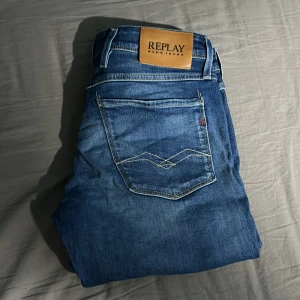 Blå jeans från Replay - Snygga blå jeans från Replay i modellen Anbass. De har en slim fit passform och är tillverkade i ett klassiskt jeansmaterial. Perfekta för en stilren look med en modern touch.