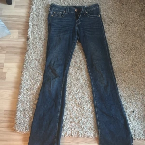 Lågmidjade True Religion rosa  - Låga true religion jeans med rosa broderade fickor, inte jätte mycket använda, trampat upp benen längst ner. Nypris 1499, säljer för 700, kan sänkas 
