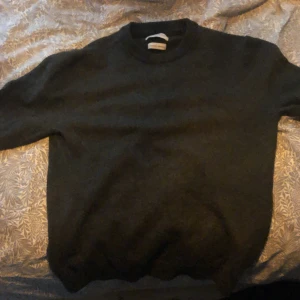 Mörkgrå stickadtröja från These Glory Days - Säljer en skitsnygg mörkgrå stickad tröja från These Glory Days i Superior Merino. Tröjan har inga defekter och är mycket bra skick. Är en  smal men passar som en extra smal