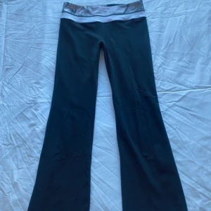 Svarta träningsbyxor från Lululemon - Snygga svarta träningsbyxor från Lululemon i bra skick! Byxorna har en bootcut-stil. Går att vika ner så blir de lågmidjade💕köpta för 600kr. midjemått: 39cm, innerbenslängd: 80cm🩷 bara att skriva vid eventuell fråga!