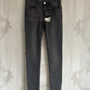 NYA Svarta slim jeans - Snygga svarta slim jeans från Unique Denim/ Cubus med låg midja. Perfekta för en stilren look. Klassisk femficksdesign och knappgylf. Passar utmärkt till både vardag och fest.