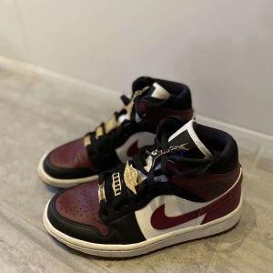 Nike Air Jordan  - Nike Air Jordan 1 Retro Mid SE "Beetroot Maroon Gold Pendant" säljes. Storlek 35.5 dam, i mycket bra skick, endast använts ett par gånger. Köpt för 2 200 kr, säljs för 1500 kr.