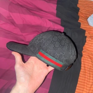 Svart Gucci keps - Svart GG canvas keps i storlek medium, köpt begagnat för 2 år sedan, jag har använt den väldigt sparsamt och den ser näst intill ny ut. Skriv till mig om ni har frågor. (priset kan diskuteras)