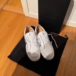 Vita sneakers från Giuseppe Zanotti -  Giuseppe Zanotti storlek 46 oanvända. Kvitto och box finns. Säljer pga av fel storlek. 