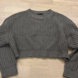 Grå stickad croppad tröja  - Säljer en grå stickad croppad tröja från Shein. Tröjan har en grovstickad design med långa ärmar och ribbade kanter. Inte värd mycket därför det låga priset. Snabb affär. 