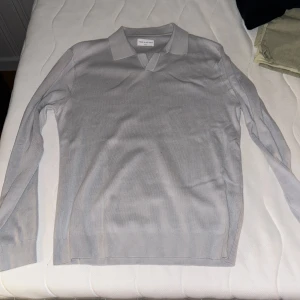 Blå tröja från These Glory Days - Säljer en stilren blå tröja från These Glory Days. Tröjan har en klassisk krage och långa ärmar, perfekt för en elegant vardagslook. Materialet är mjukt och bekvämt.