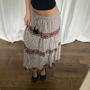 Mönstrad kjol - Mönstrad kjol från Indiska. Midjemått: 76-90 cm, 38-45 cm mätt platt. Längd: 73 cm