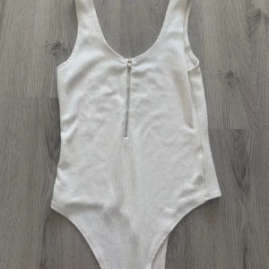 Vit Body från Bik Bok - Snygg vit body från Bik Bok med dragkedja framtill. 