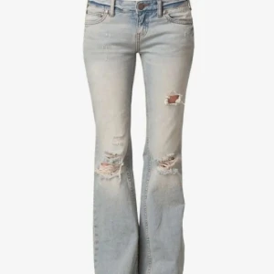 Ljusblå bootcut jeans med hål - Jeans som liknar de trendiga och eftertraktade free people jeansen. Från vinted. En liten fläck men den syns ej och tror den borde gå bort. Jag är 170. Midja 40 cm innerben 80 cm🚨jeansen är paxade för 450 så buda över det om ni vill ha dem🚨