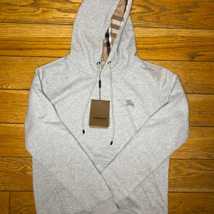 Burberry Hoodie  - Hej! Säljer en helt ny grå Burberry hoodie. Den har aldrig använts. Storleken är large. Känn dig fri att kontakta om du har frågor.