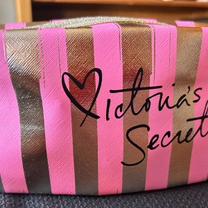 Necessär från VS! - Necessär från Victoria's Secret i guld och rosa med avtagbart handtag och dragkedja. Mått: 10 x 20 cm. Oanvänd.