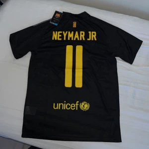 Oanvänd ”Neymar 11” Fc Barcelona fotbollströja  - Fet Neymar tröja säljs billigt med tanke på att den är oanvänd och med tagg fastän modellen är från 2011 och är även väldigt svår att få tag på just nu. Storlek M men kan även passa stora S. Kom dm direkt om du undrar nåt. Fler fotbollströjor på min sida.