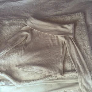 Beige ribbad offshoulder-tröja - Säljer en beige ribbad offshoulder-tröja med långa ärmar. Har aldrig använt den. Hör av dig vid intresse!