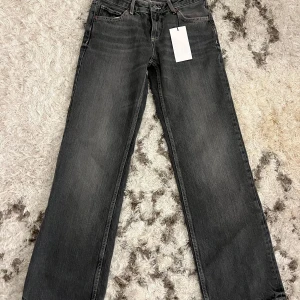 Grå lågmidjade jeans! - Snygga grå jeansbyxor med en klassisk straight passform. De har en traditionell femficksdesign och en knappgylf. Perfekta för en avslappnad stil. Oanvända med prislapp!!